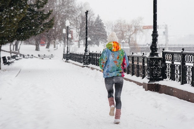 belle jeune fille fait du jogging un jour givré et neigeux. Sports, mode de vie sain