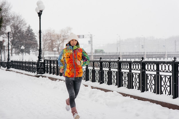 belle jeune fille fait du jogging un jour givré et neigeux. Sports, mode de vie sain