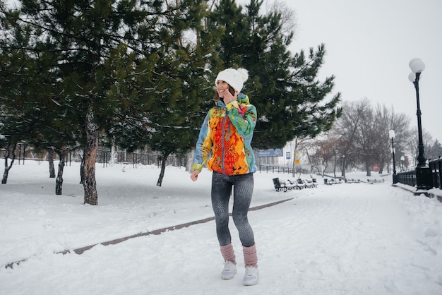 belle jeune fille fait du jogging un jour givré et neigeux. Sports, mode de vie sain