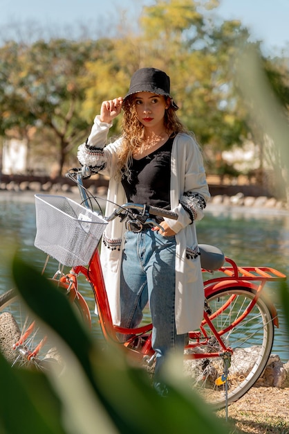 Belle jeune fille fait du vélo dans le parc