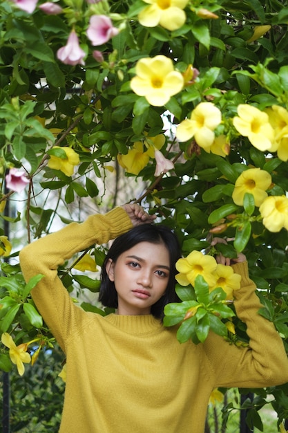 Belle jeune fille à fleurs jaunes et pull jaune