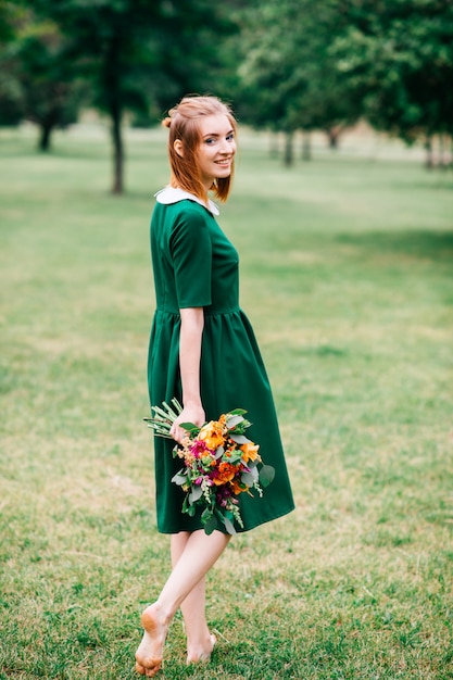 Belle jeune fille foxy en robe élégante verte portrait de mode de vie d'été en plein air. Assez gai loisirs femme nue aux pieds dans la nature