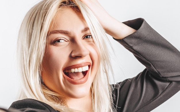 Belle jeune fille heureuse sur fond isolé gris