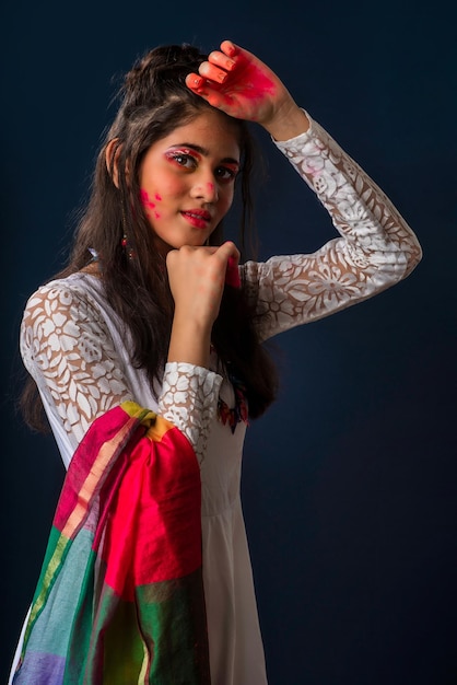 Une belle jeune fille joue avec les couleurs à l'occasion de Holi Le concept du festival indien Holi