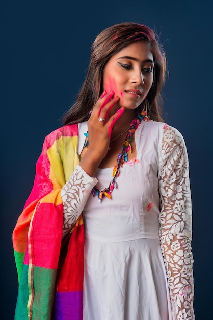 Photo une belle jeune fille joue avec les couleurs à l'occasion de holi le concept du festival indien holi