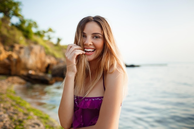 Belle jeune fille joyeuse se repose sur la plage du matin