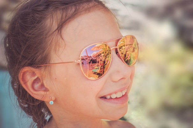 Une Belle Fille En Lunettes De Soleil Se Trouve Dans Un Siège De Voiture  Enfant Dans La Voiture Et Regarde Par La Fenêtre. Voyage Image stock -  Image du piloter, confortable: 221996591