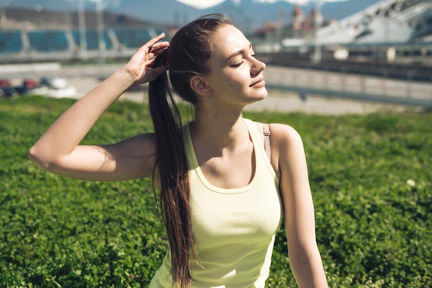 Belle jeune fille paisible se reposant et se relaxant au soleil sur une herbe verte