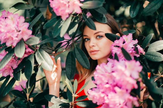 Belle jeune fille posant parmi l'arbre en fleurs