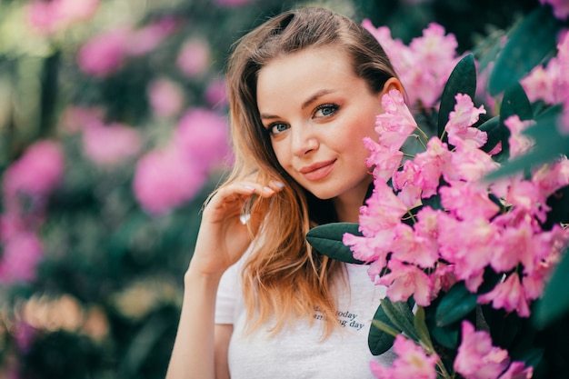 Belle jeune fille posant parmi l'arbre en fleurs