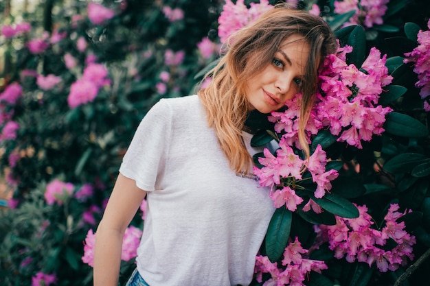 Belle jeune fille posant parmi l'arbre en fleurs