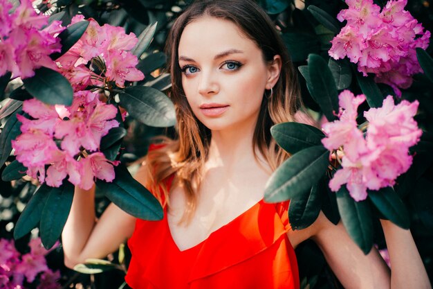 Belle jeune fille posant parmi l'arbre en fleurs