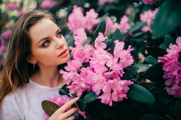 Belle jeune fille posant parmi l'arbre en fleurs