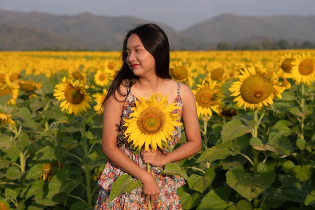 Belle jeune fille profite du temps au champ de fleurs