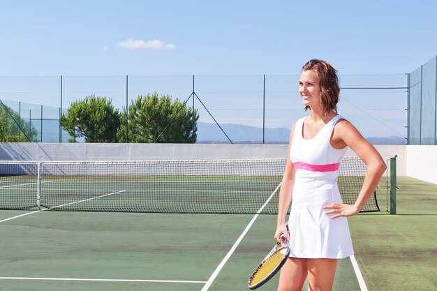 Belle jeune fille avec une raquette de tennis prête à exercer. Fermer.