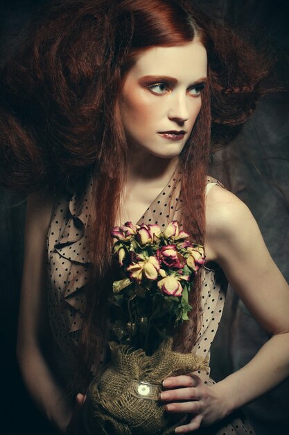 Belle jeune fille avec des roses sèches en décoration, maquillage créatif, concept artistique