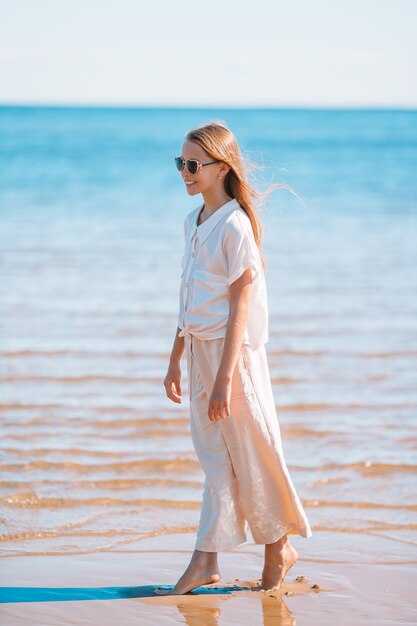 Belle jeune fille s'amuser au bord de mer tropical.