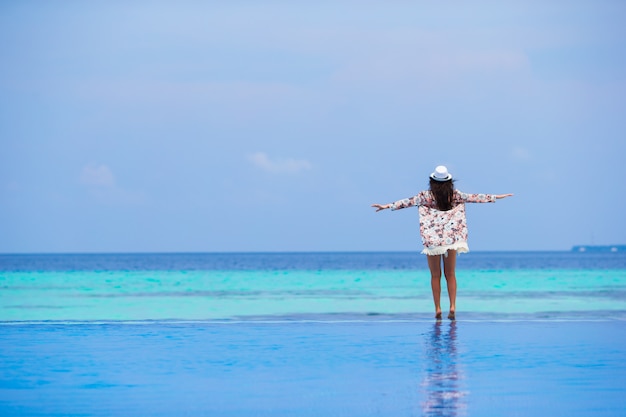 Belle jeune fille se détendre dans la piscine extérieure