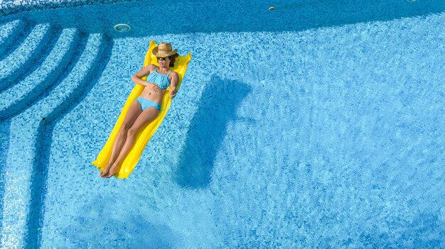 Belle jeune fille se détendre dans la piscine femme sur vue aérienne de matelas gonflable