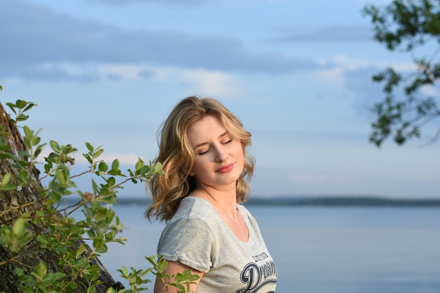 Belle jeune fille se reposant sur une soirée d&#39;été dans la nature et dans la ville