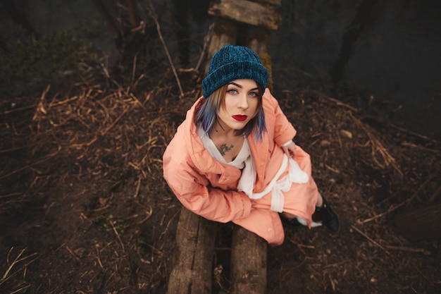 Belle jeune fille se repose, assise sur un petit pont de bois