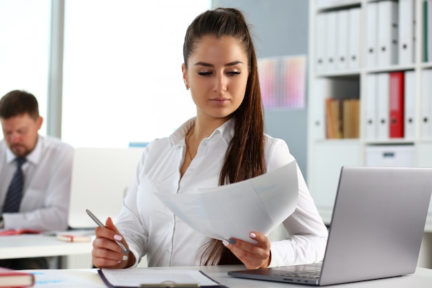 Belle jeune fille souriante au travail regarder à huis clos