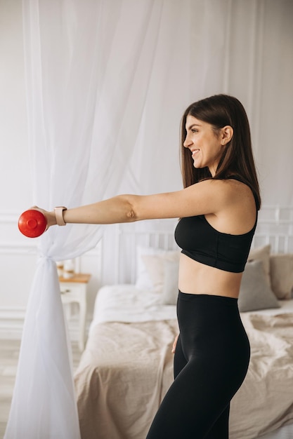 Belle jeune fille sportive faisant des exercices avec des haltères à la maison photo de haute qualité