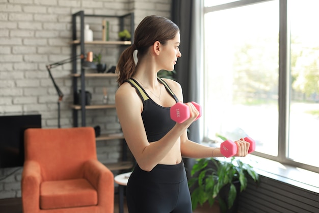 Un Modèle Féminin Axé Sur Le Fitness En Vêtements De Sport Capturé En Cours  D'entraînement Dans Une Salle De Sport Moderne