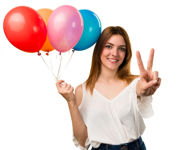 Belle jeune fille tenant un ballon et comptant deux