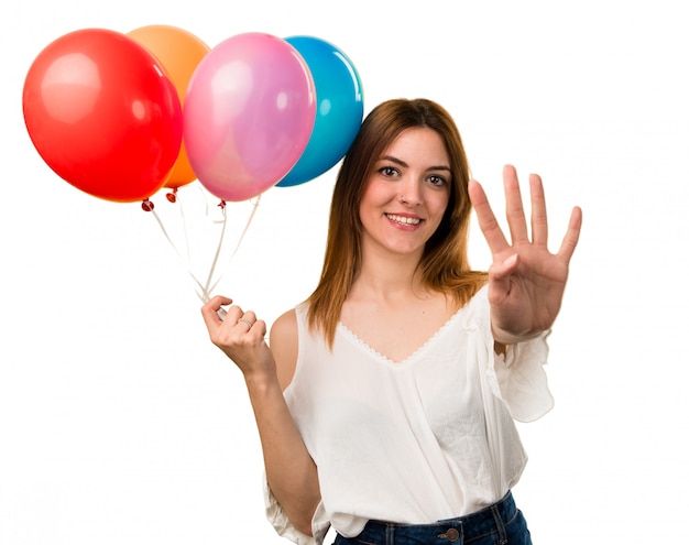 Belle jeune fille tenant un ballon et comptant quatre