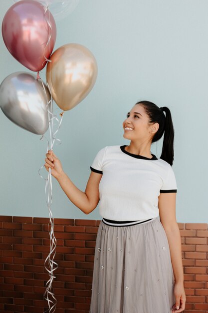 Belle jeune fille tenant des ballons à gaz