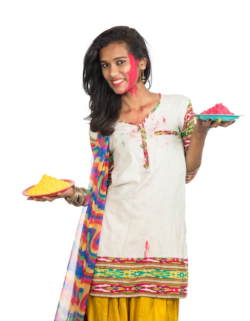 Belle jeune fille tenant la couleur en poudre dans la plaque à l'occasion du festival Holi.