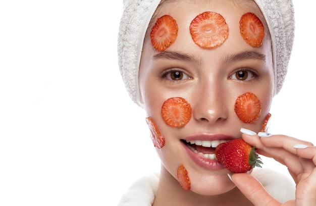 Belle jeune fille tendre dans une serviette blanche avec une peau fraîche et propre posant devant la caméra. Beau visage. Soin de la peau. Photo prise en studio sur fond blanc isolé.