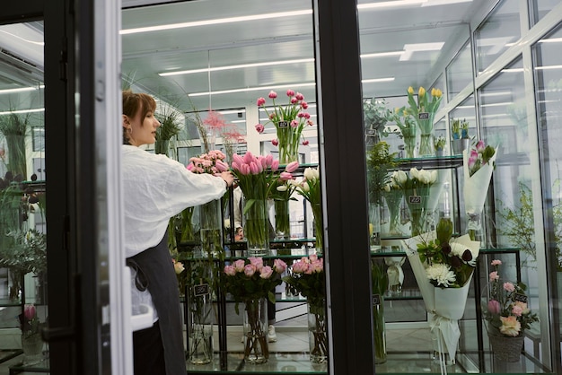 Belle jeune fleuriste fait un bouquet