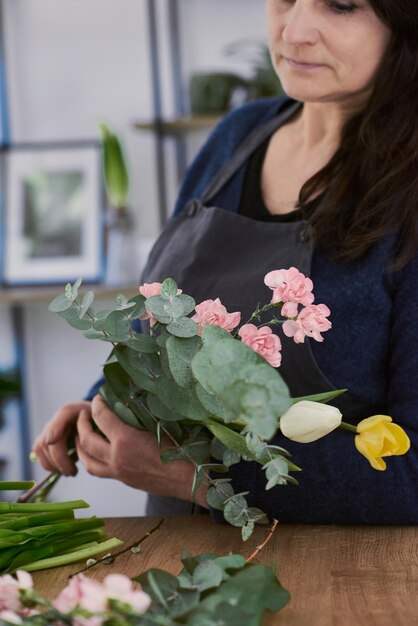 Belle jeune fleuriste fait un bouquet