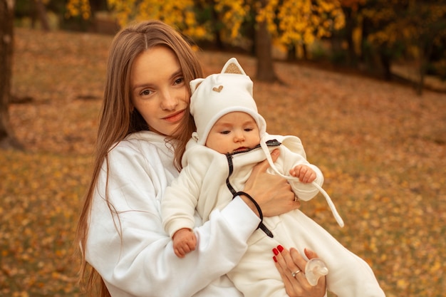 Belle jeune maman avec bébé fille à l'automne