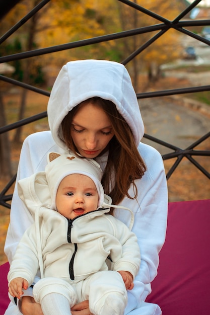 Belle jeune maman avec petite fille en automne