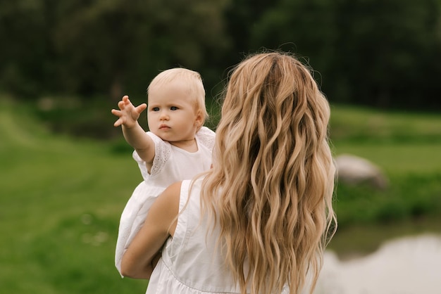 Belle jeune maman avec sa fille d'un an dans la nature