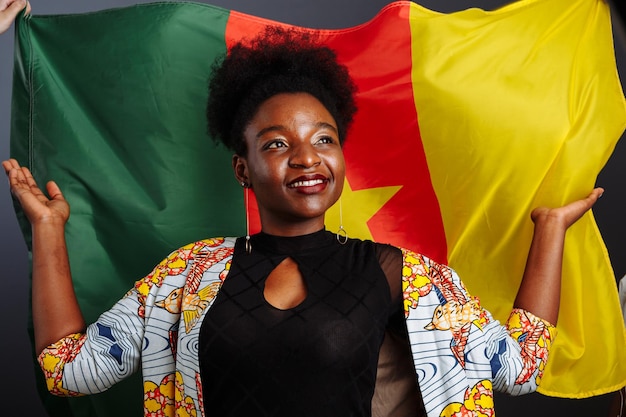 Belle jeune mannequin africaine avec le drapeau du Cameroun en costume traditionnel