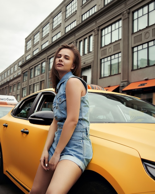 Belle jeune mannequin à la mode dans les rues d'une grande ville