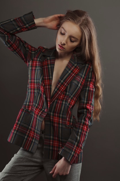 Belle jeune mannequin posant pour des tests de modèle en veste tartan