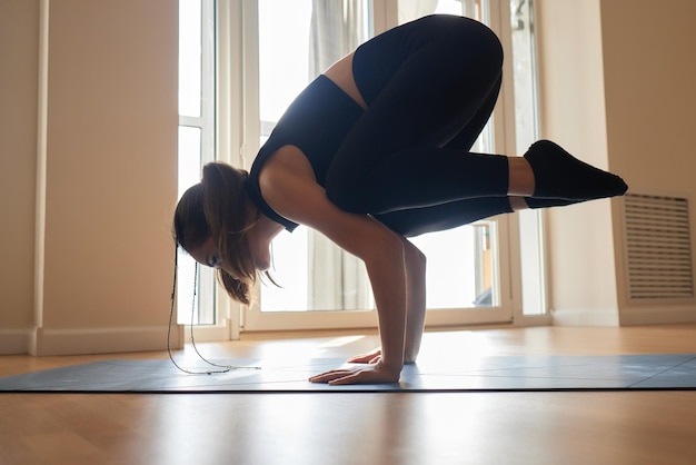 Belle jeune mannequin travaillant à la maison faisant de l'exercice de fitness au sol paripurna navasana pour upp