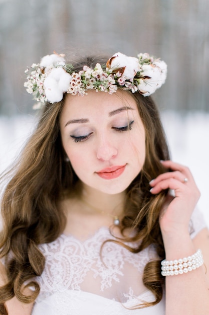 Belle jeune mariée dans la forêt enneigée d'hiver