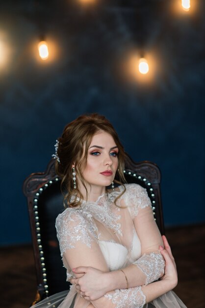 Belle jeune mariée dans une lingerie blanche. Derniers préparatifs du mariage en attendant le marié.
