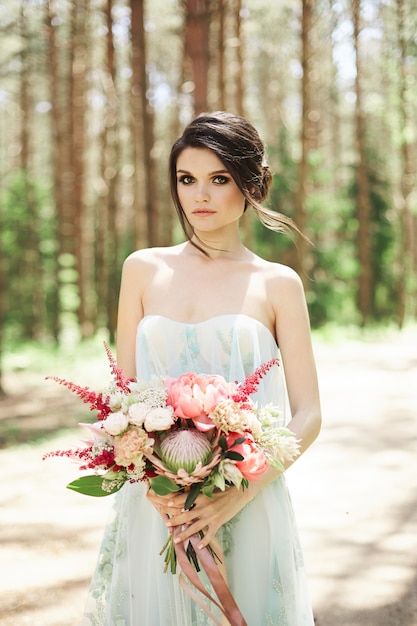 Belle jeune mariée dans une robe de mariée bleue