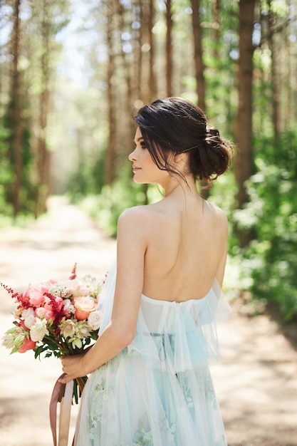 Belle jeune mariée dans une robe de mariée bleue