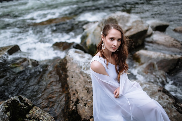 Belle jeune mariée dans une robe de mariée dans la nature