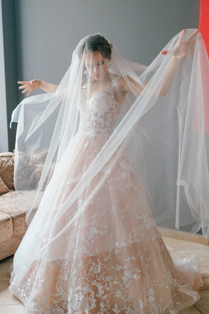 Belle jeune mariée en robe de mariée posant,