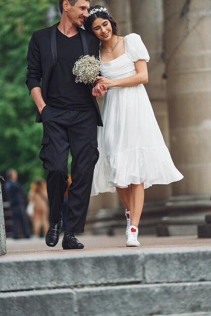 La belle jeune mariée avec son fiancé célèbre le mariage dehors