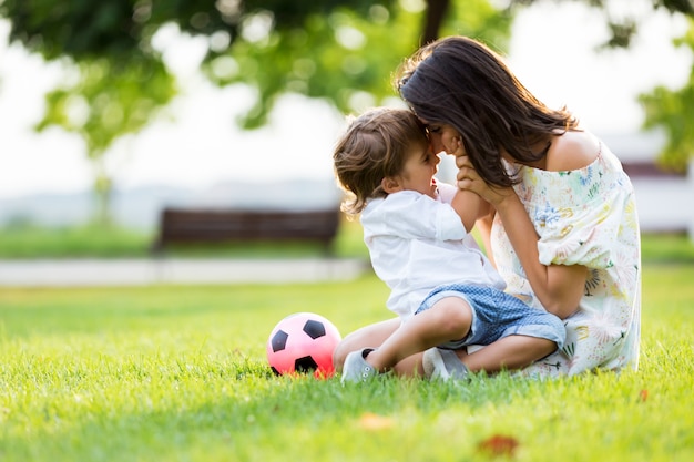 Belle jeune mère amoureuse de son fils dans le parc.